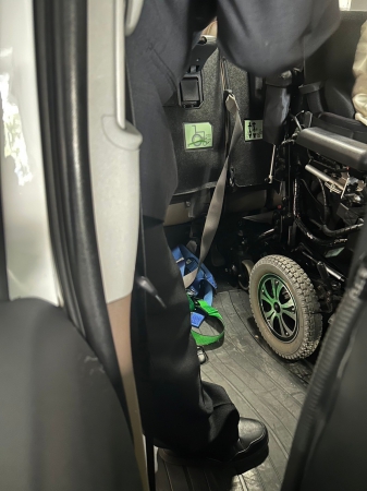 車内で車いすを固定する器具の位置を乗務員が確認している