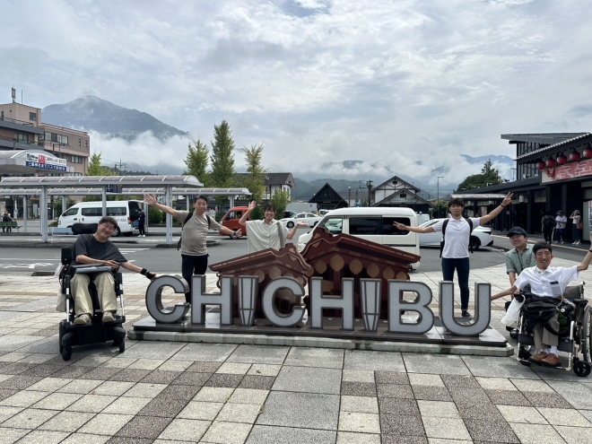 写真:西部秩父駅の前の”CHICHIBU”と書かれたモニュメントの前で